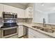 Well-appointed kitchen featuring stainless steel appliances, granite countertops, white cabinetry, and a stylish backsplash at 4207 S Dale Mabry Hwy # 2105, Tampa, FL 33611