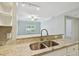 Modern kitchen featuring granite countertops, stainless sink, and open view to the living space at 4207 S Dale Mabry Hwy # 2105, Tampa, FL 33611