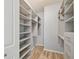 Spacious walk-in closet with built in shelving and drawers, wood-look floors, and neutral walls at 4207 S Dale Mabry Hwy # 2105, Tampa, FL 33611
