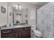 Bathroom with a granite-topped vanity and a shower with a decorative curtain at 4212 W La Salle St, Tampa, FL 33607