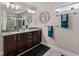 Double vanity bathroom with granite counters, dark cabinets, and decorative wall art at 4212 W La Salle St, Tampa, FL 33607