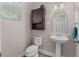 Charming half bath featuring a pedestal sink, decorative mirror, and stylish cabinet at 4212 W La Salle St, Tampa, FL 33607