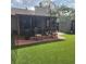 Secluded backyard oasis with screened-in porch, lush artificial grass, and storage shed at 5119 Hector Ct, Tampa, FL 33624
