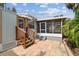 Back patio with a screened-in porch, wooden stairs, and lush landscaping at 535 6Th N St, St Petersburg, FL 33701