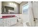 Bathroom with white vanity, unique red counter, patterned tile floor, and tiled shower/tub at 535 6Th N St, St Petersburg, FL 33701