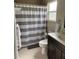 Bathroom features a shower with gray striped curtain and a vanity with dark cabinets at 535 6Th N St, St Petersburg, FL 33701
