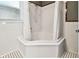 Bathroom featuring a corner tub with white tiled walls and unique patterned tile flooring at 535 6Th N St, St Petersburg, FL 33701