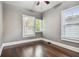 Bright bedroom with hardwood floors, two windows, ceiling fan, and neutral-toned walls at 535 6Th N St, St Petersburg, FL 33701
