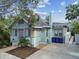 Charming single-story home featuring a light blue exterior, a purple front door, and a well-maintained front yard at 535 6Th N St, St Petersburg, FL 33701