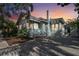 Charming single-story home featuring a light blue exterior, a purple front door, and a well-maintained yard at sunset at 535 6Th N St, St Petersburg, FL 33701