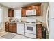 Charming kitchen features warm wood cabinetry, granite countertops, and white appliances at 535 6Th N St, St Petersburg, FL 33701