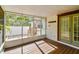 Screened-in porch with wooden floor, view of a landscaped backyard, and access to outdoor staircase at 535 6Th N St, St Petersburg, FL 33701