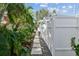 Walkway alongside a white fence lined with lush tropical plants and gravel at 535 6Th N St, St Petersburg, FL 33701