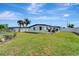 Spacious backyard featuring a well-maintained lawn, patio seating, and a privacy fence for outdoor enjoyment at 551 Lindley Ter, Port Charlotte, FL 33952