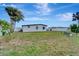 Large backyard featuring a well-maintained lawn, patio seating, and a privacy fence for outdoor enjoyment at 551 Lindley Ter, Port Charlotte, FL 33952