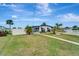 Charming single-story home with a well-manicured lawn, modern windows, and a white fence in a waterfront neighborhood at 551 Lindley Ter, Port Charlotte, FL 33952