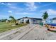 Charming home featuring mature landscaping, covered carport, and a well-maintained lawn, creating inviting curb appeal at 551 Lindley Ter, Port Charlotte, FL 33952