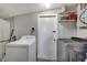 Efficient laundry room equipped with modern washer and dryer units, plus shelving for easy storage at 551 Lindley Ter, Port Charlotte, FL 33952