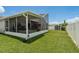 A spacious backyard features a screened porch and lush green lawn at 5826 Taywood Dr, Tampa, FL 33624