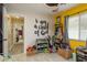 Bedroom with yellow accent walls, a ceiling fan, and an array of storage solutions for toys and clothes at 5826 Taywood Dr, Tampa, FL 33624