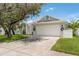 Charming single-story home featuring a well-manicured lawn and a two-car garage with wreaths at 5826 Taywood Dr, Tampa, FL 33624
