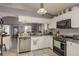 Well-lit kitchen with white cabinets, stainless steel appliances, and gray tile backsplash at 5826 Taywood Dr, Tampa, FL 33624