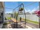 Enclosed patio showcasing an outdoor dining setup, hanging plants, and a view of the fenced backyard at 5826 Taywood Dr, Tampa, FL 33624