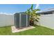 A metal shed is nestled near a white vinyl fence with tropical landscaping at 5826 Taywood Dr, Tampa, FL 33624