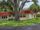 Charming single-story condo featuring a distinctive red roof, lush lawn, and mature shade trees at 5865 37Th N Ave # 26, St Petersburg, FL 33710