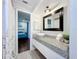 Bathroom featuring a modern vessel sink, granite countertop, framed mirror, and wood-look flooring at 6682 Mauna Loa Blvd, Sarasota, FL 34241