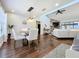 Bright dining area featuring wood floors and elegant light fixture open to a cozy living room at 6682 Mauna Loa Blvd, Sarasota, FL 34241