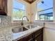 Close-up of the kitchen sink featuring granite countertops and a view of the outdoor pool area at 6682 Mauna Loa Blvd, Sarasota, FL 34241