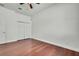 Clean bedroom featuring hardwood floors, closet, white trim, and ample open space for versatile use at 710 W Peninsular St, Tampa, FL 33603