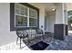 Stylish front porch seating area with modern chairs, side table, and decorative tile flooring at 710 W Peninsular St, Tampa, FL 33603