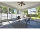 The screened patio featuring a ceiling fan and seating area invites relaxation and outdoor enjoyment at 710 W Peninsular St, Tampa, FL 33603