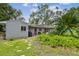View of backyard with landscaping, brick path, and patio with gray house in background at 7219 4Th N Ave, St Petersburg, FL 33710