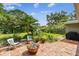 Landscaped backyard featuring a brick paver patio, lush green plants, and a fire pit at 7219 4Th N Ave, St Petersburg, FL 33710