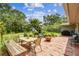 Tile patio in landscaped backyard with dining set, seating area, fire pit, and grill at 7219 4Th N Ave, St Petersburg, FL 33710