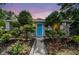 Charming home front featuring a bright blue door framed by well-manicured trees at 7219 4Th N Ave, St Petersburg, FL 33710