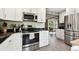Bright kitchen features stainless steel appliances, granite countertops, and sleek white cabinetry and opens to adjacent room at 7219 4Th N Ave, St Petersburg, FL 33710