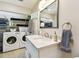 Bathroom with laundry including storage shelves, new washer and dryer, and marble countertop at 7219 4Th N Ave, St Petersburg, FL 33710