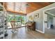 Sunlit living room with a wood-paneled ceiling, large windows, piano and seating areas at 7219 4Th N Ave, St Petersburg, FL 33710