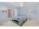 Light blue bedroom with ceiling fan, sliding glass doors, and neutral-toned carpet at 7705 4Th W Ave, Bradenton, FL 34209
