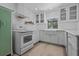 Well-lit kitchen with white appliances, stylish cabinetry, and wood-look flooring at 7705 4Th W Ave, Bradenton, FL 34209