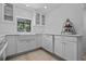 Bright kitchen boasts white cabinets, sleek countertops, and a farmhouse sink with a view of the backyard at 7705 4Th W Ave, Bradenton, FL 34209