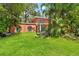 The backyard features a manicured lawn, mature trees, and a patio with outdoor seating at 817 S West Shore Blvd, Tampa, FL 33609