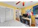 Sunlit yellow bedroom with hardwood floors, fan, closet, and computer setup at 817 S West Shore Blvd, Tampa, FL 33609