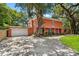 Unique two-story home with an attached garage, mature trees and a spacious driveway leading to the entrance at 817 S West Shore Blvd, Tampa, FL 33609