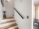Clean staircase with hardwood steps and a dark handrail offers a seamless transition between floors at 817 S West Shore Blvd, Tampa, FL 33609