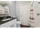 Modern bathroom with granite countertop, sleek fixtures, and a shower with striped curtain at 8410 Kenavis Pl, Odessa, FL 33556